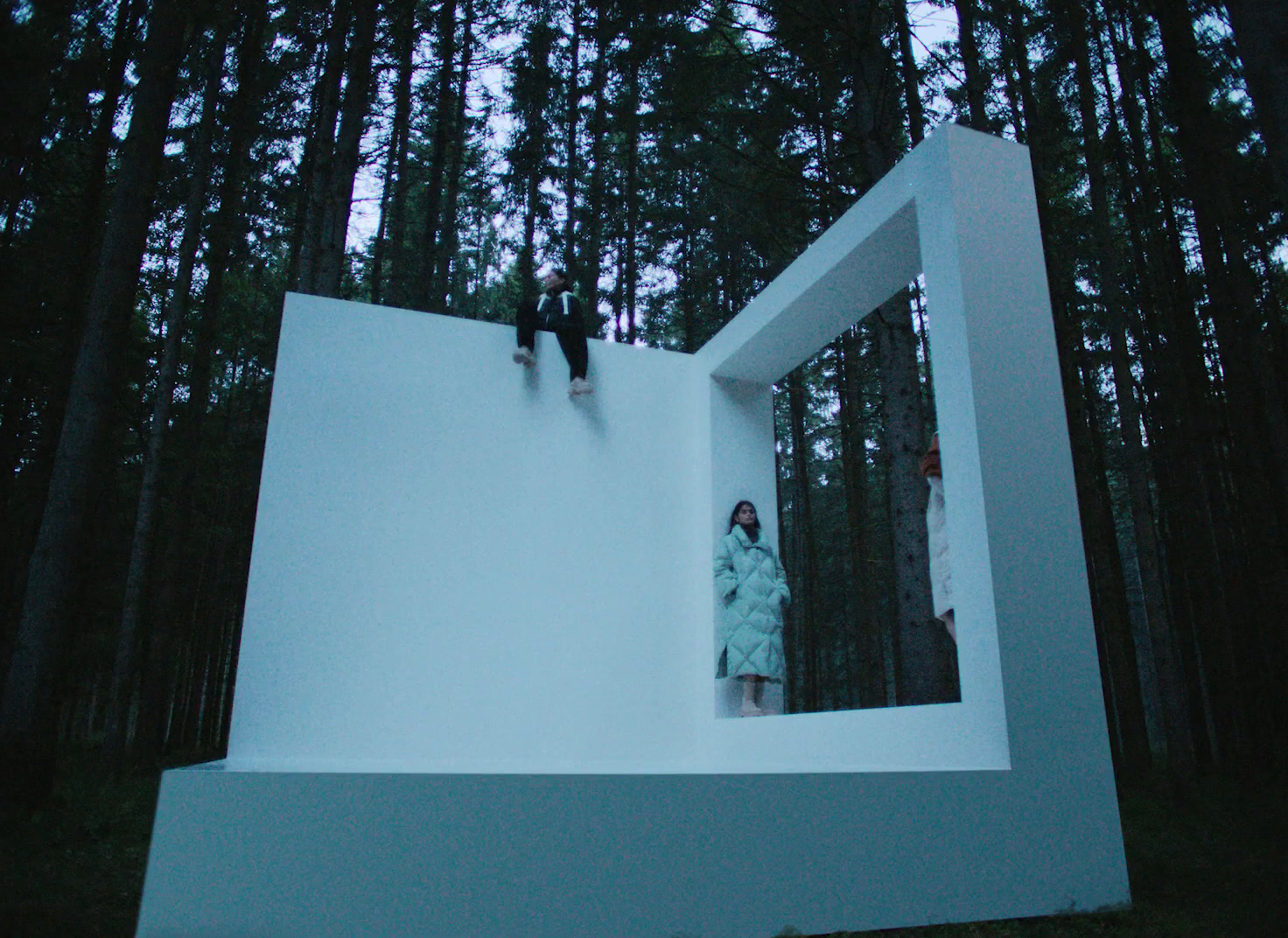 two people standing on a white structure in the woods