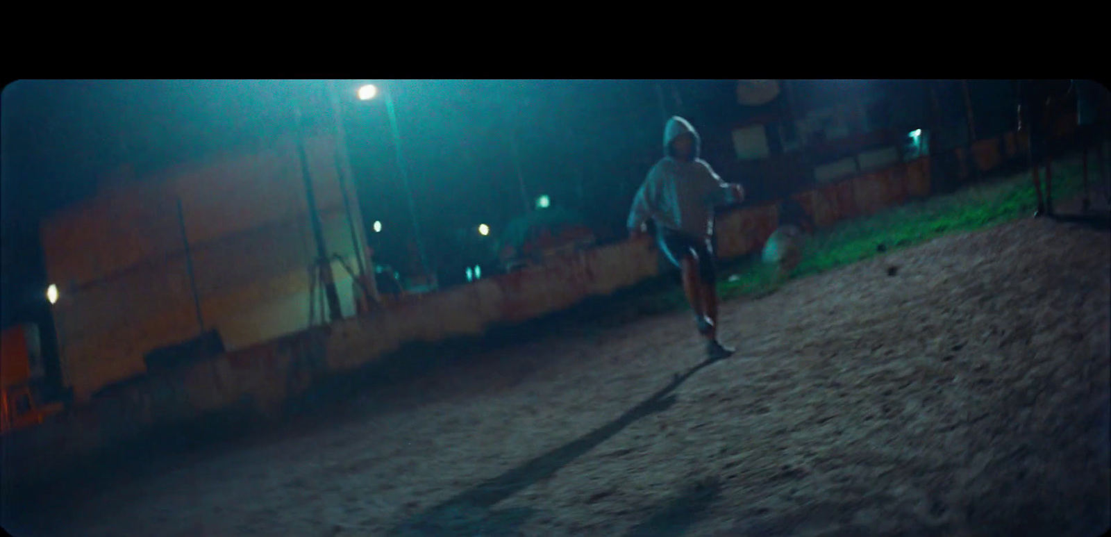 a man running down a dirt road at night