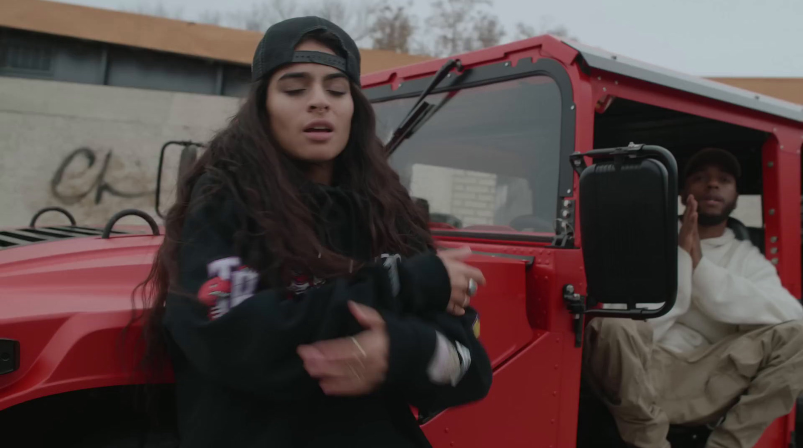 a woman sitting in the driver's seat of a red truck