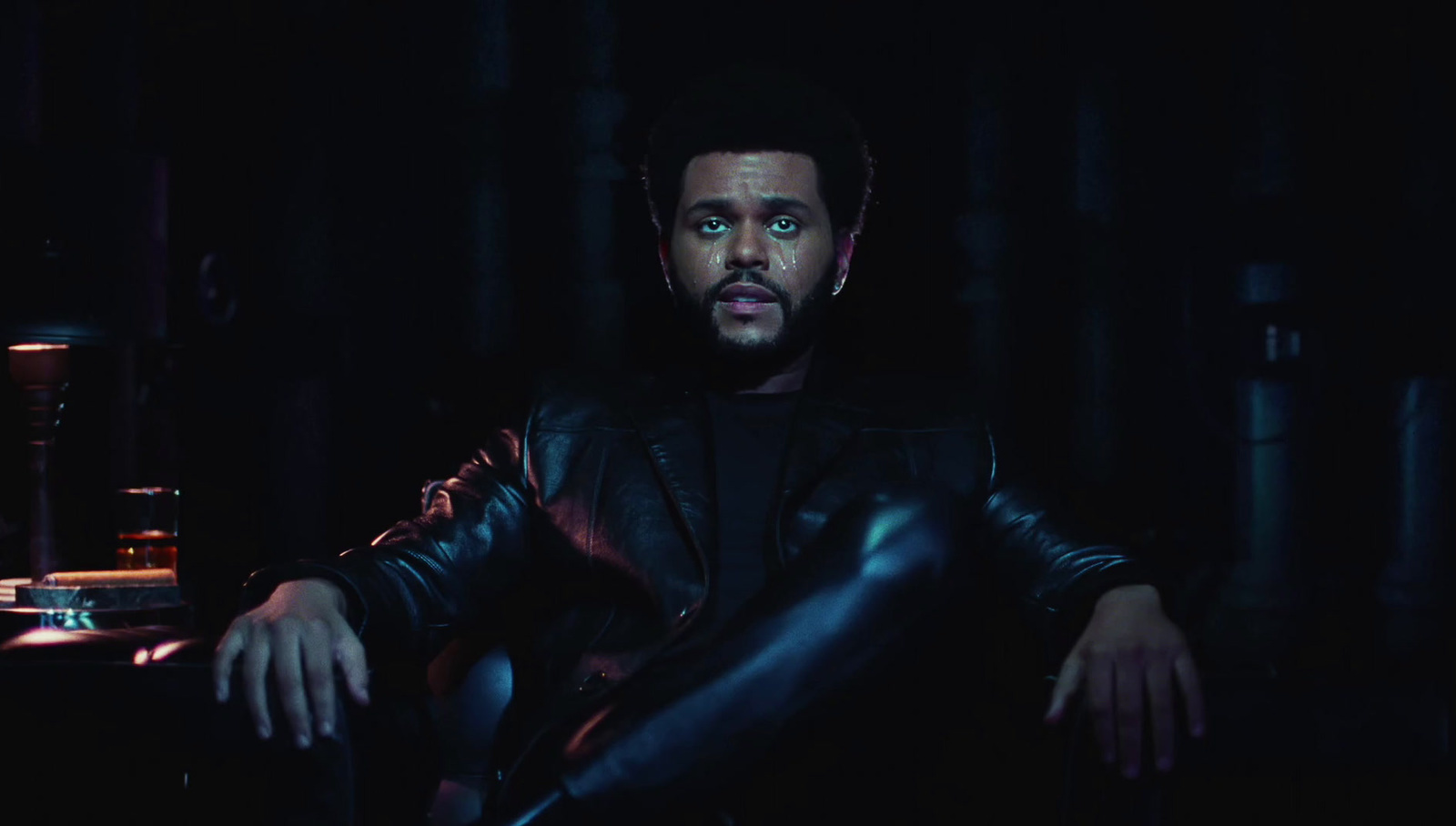 a man sitting in a chair in a dark room