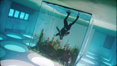 a man diving into a large aquarium filled with water