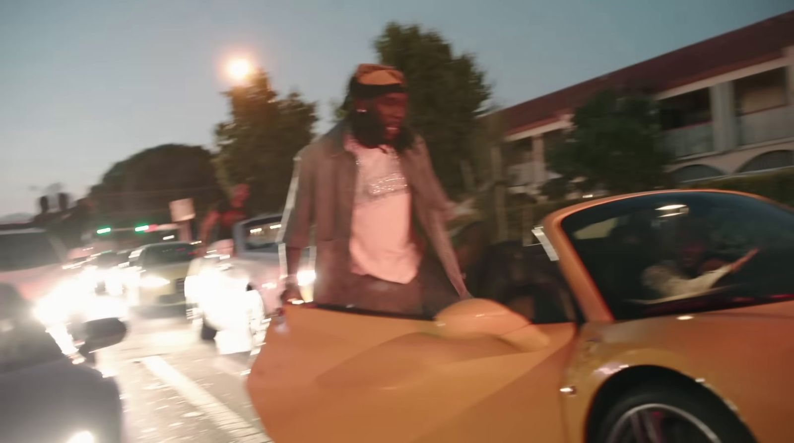 a man standing next to a car on a street