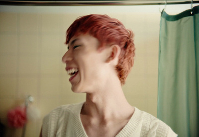 a woman with red hair laughing in a bathroom