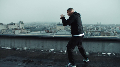 a man in a black hoodie is running on a roof