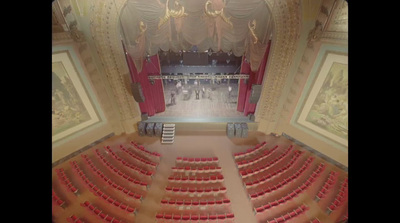 a large auditorium with red seats and a ladder