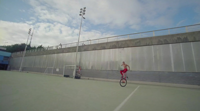 a man riding a unicycle on a tennis court