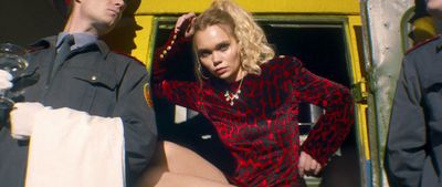 a woman in a red and black dress sitting on the back of a yellow truck