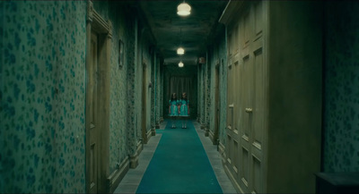 a long hallway with green walls and blue carpet