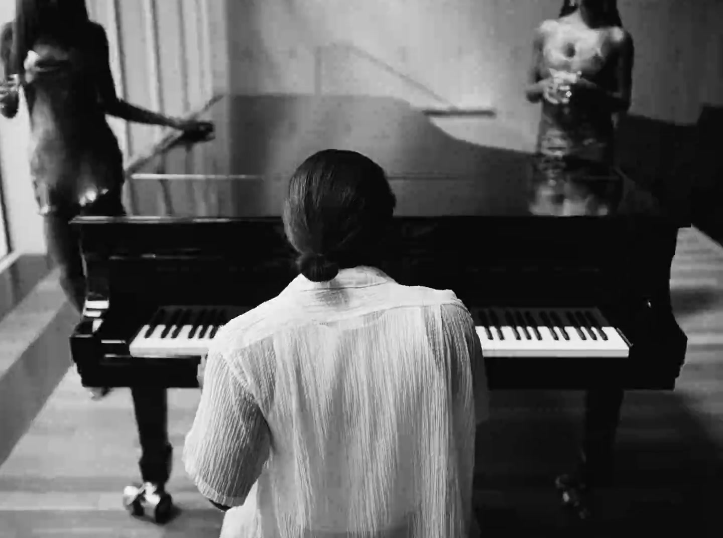 a woman standing in front of a piano in a room