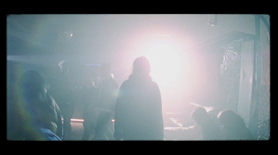 a group of people standing around in a dark room