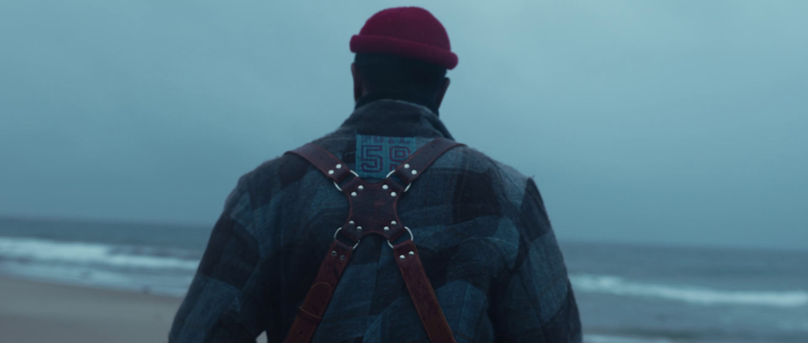 a man with a red hat is standing on the beach