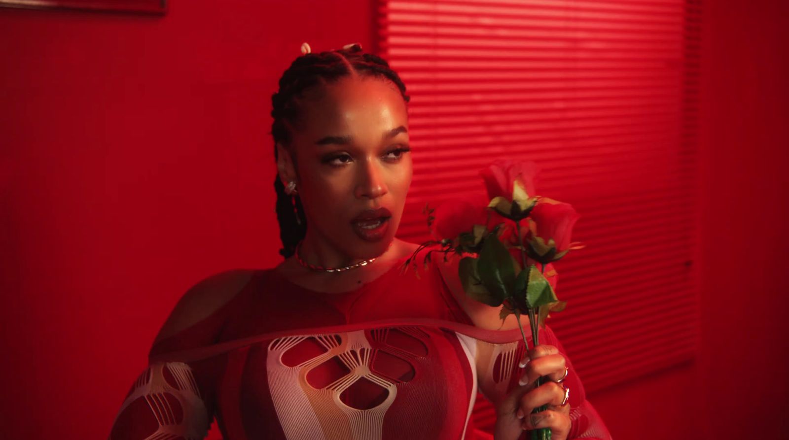 a woman in a red room holding a rose