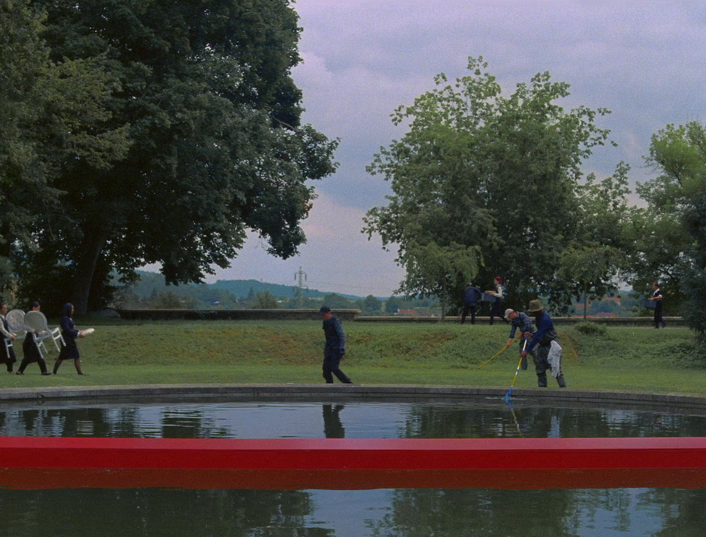 a group of people walking across a lush green field