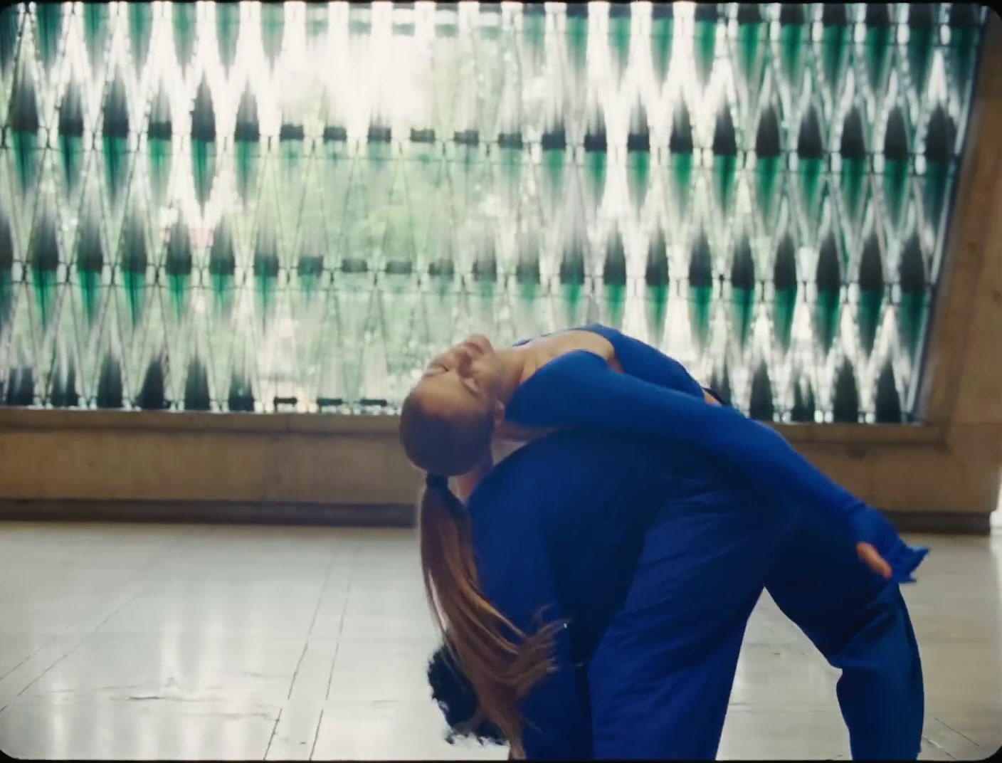 a woman in a blue shirt is doing a yoga pose