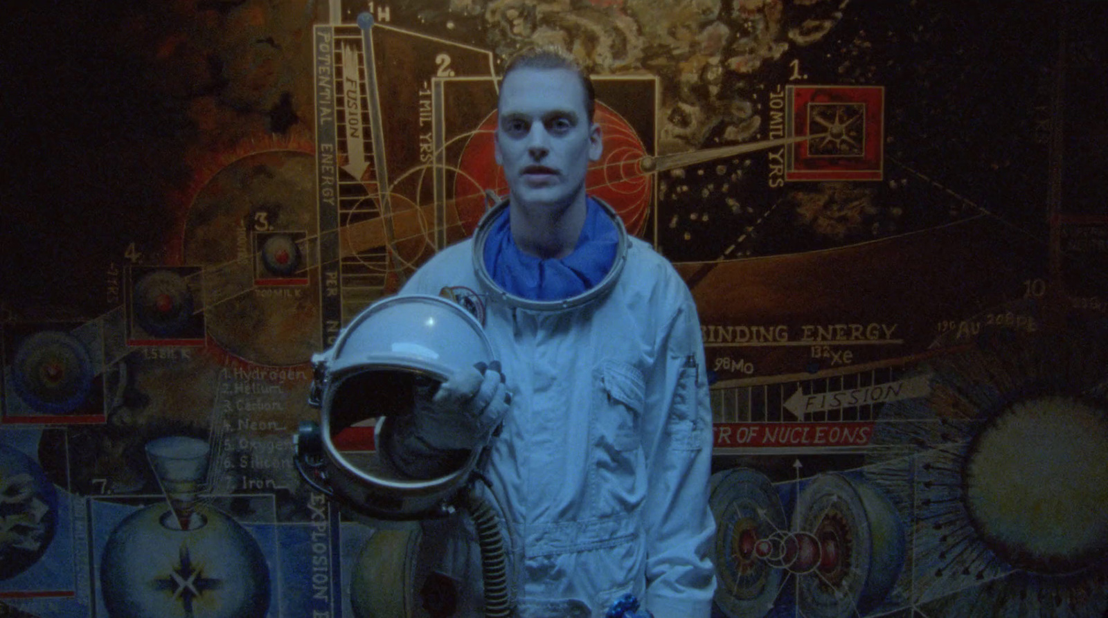 a man in a space suit standing in front of a painting