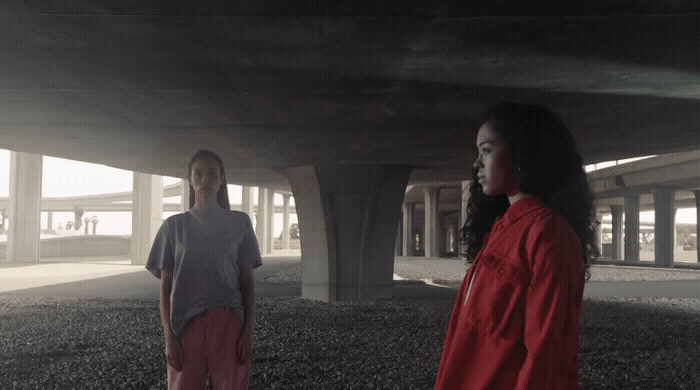 a couple of people standing under a bridge