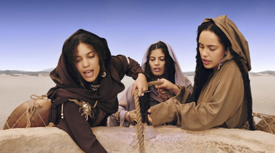 a group of women sitting on top of a rock