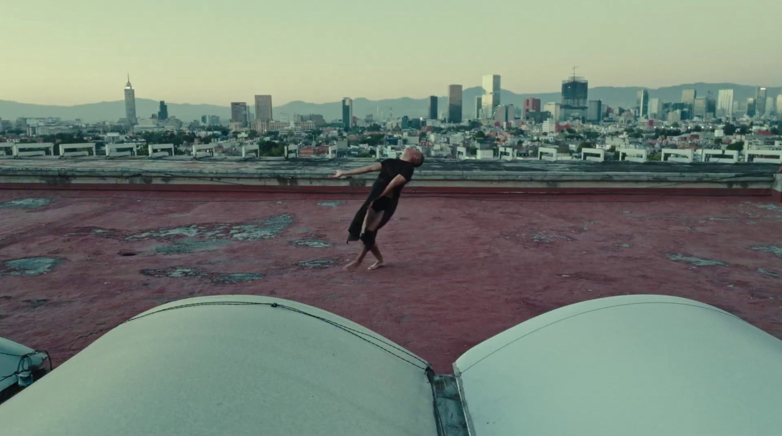 a person doing a handstand on the roof of a building