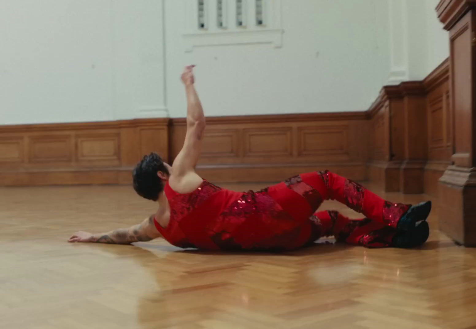 a man in a red shirt is laying on the floor