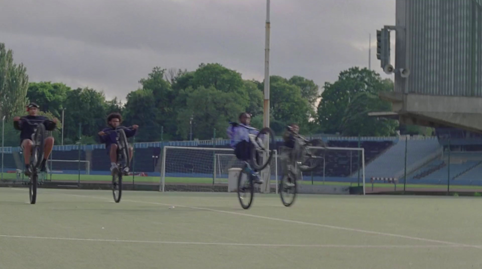 a group of people riding bikes on top of a tennis court