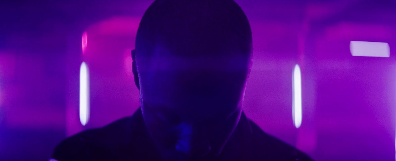 a man standing in a room with purple lights