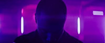 a man standing in a room with purple lights