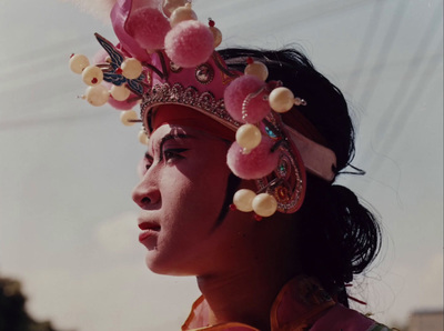 a woman wearing a pink head piece with pearls