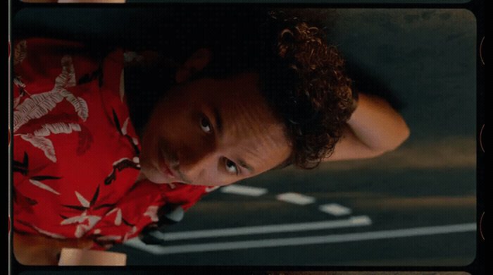 a man with curly hair wearing a red shirt