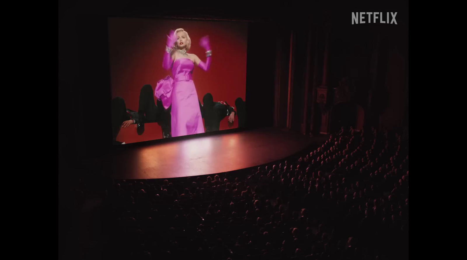 a woman in a pink dress on a stage