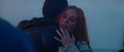 a woman with red hair is hugging a man