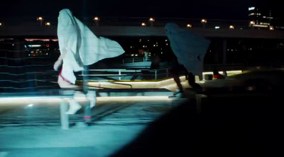 two people walking on a bridge at night