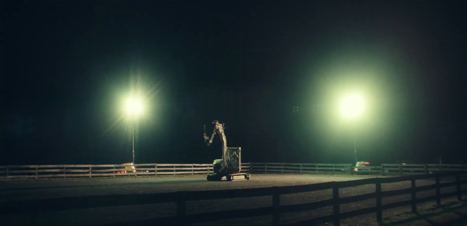 a man standing on top of a dirt field at night