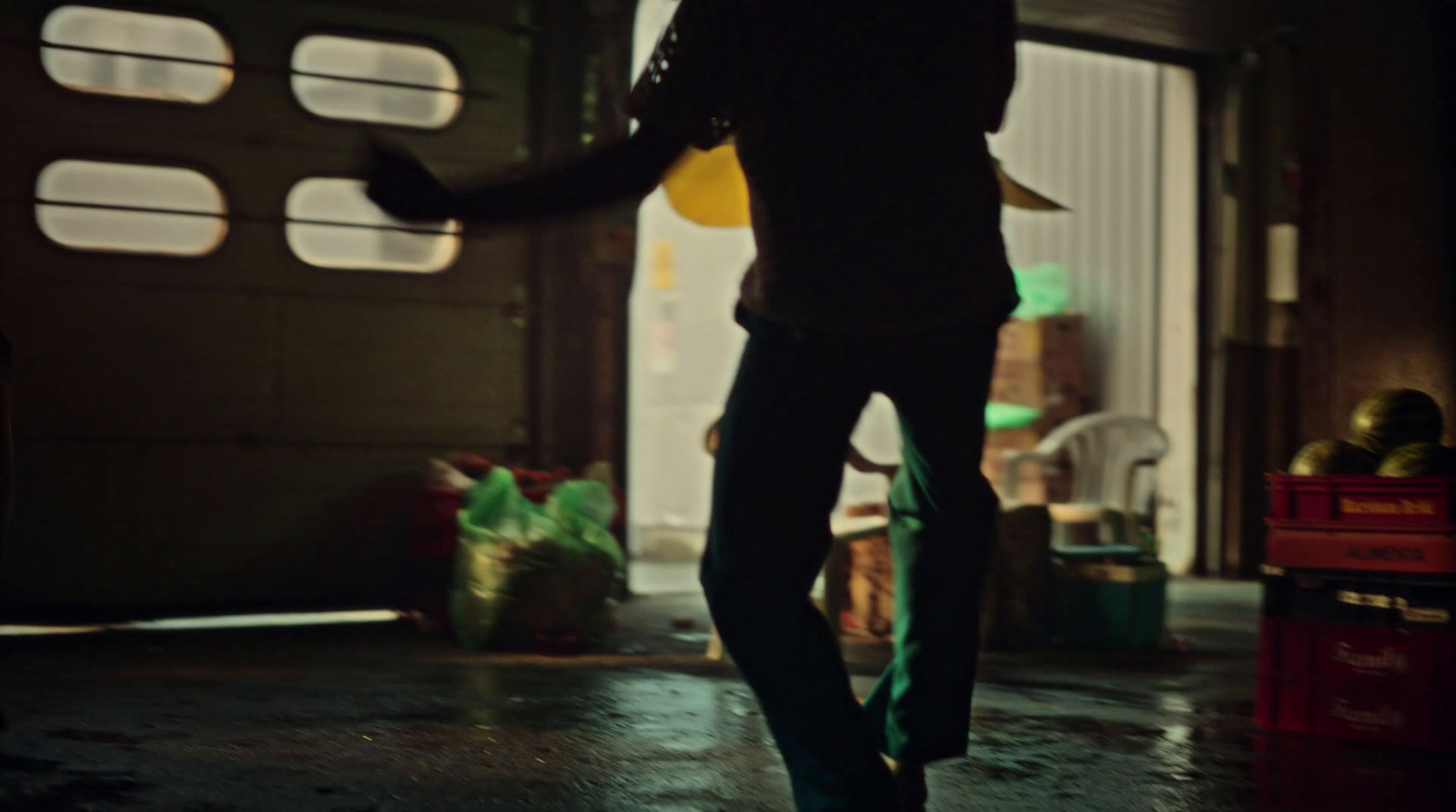 a man walking into a garage with an umbrella