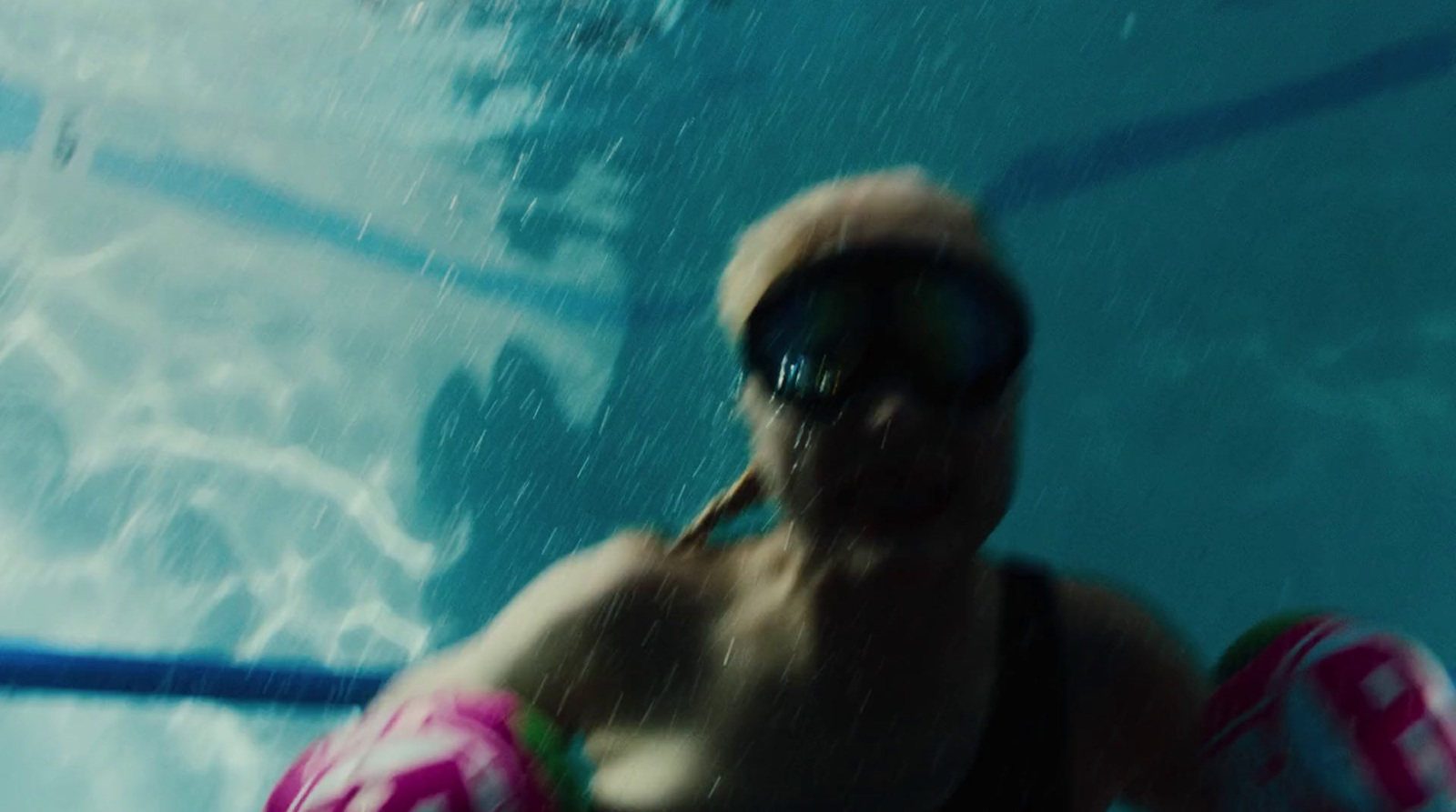 a man swimming in a pool with a life preserver