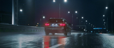 a car driving down a wet road at night