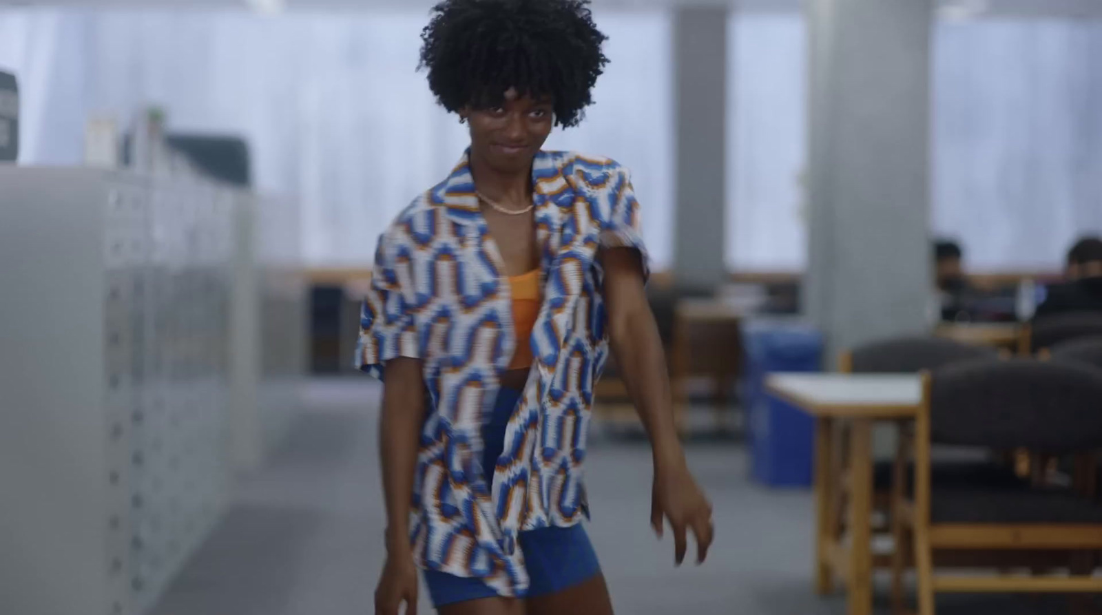 a woman walking down a hallway in an office building