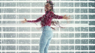 a woman standing in front of a window covered in snow