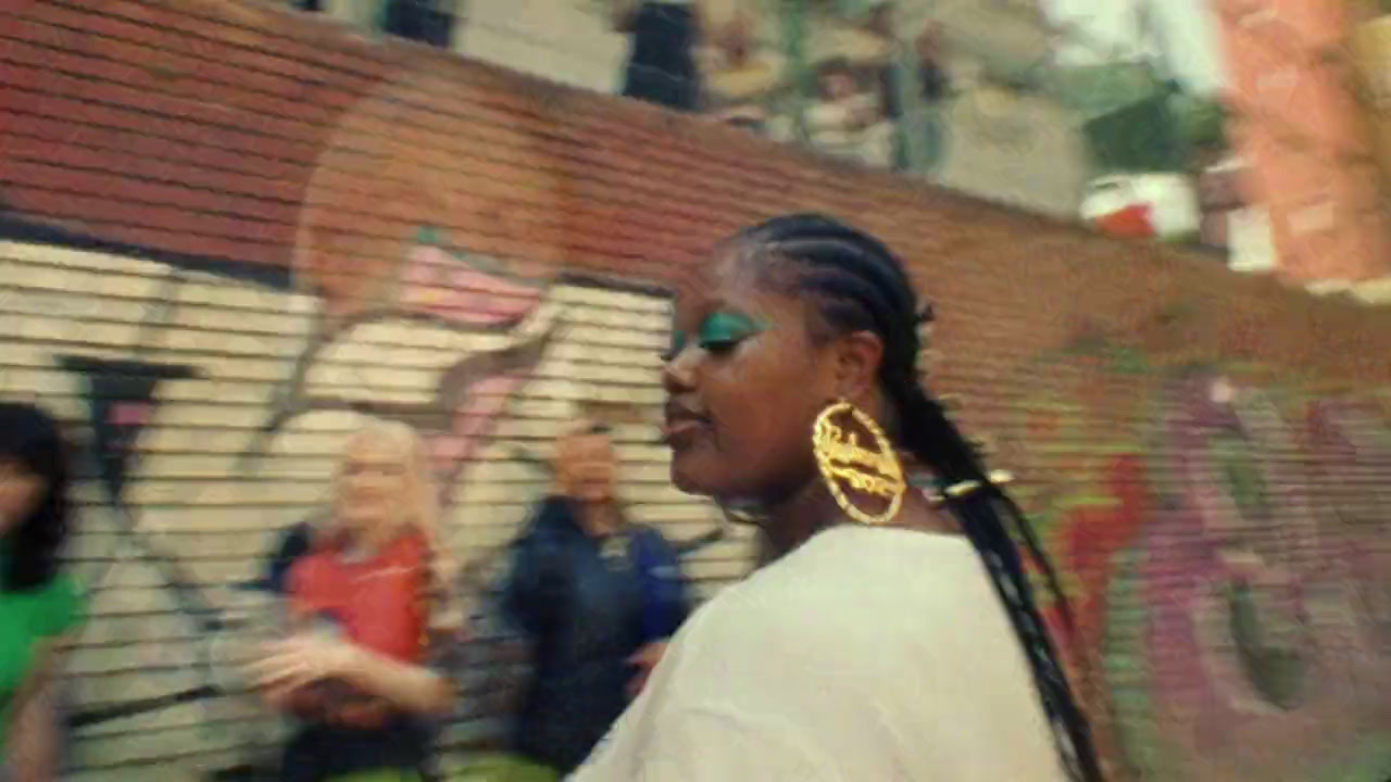 a woman with dreadlocks walking down a street