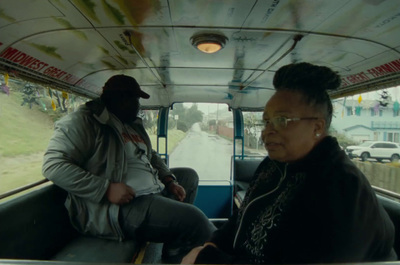 a man sitting in the back of a bus next to a woman