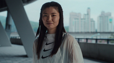 a woman with long hair standing in front of a building