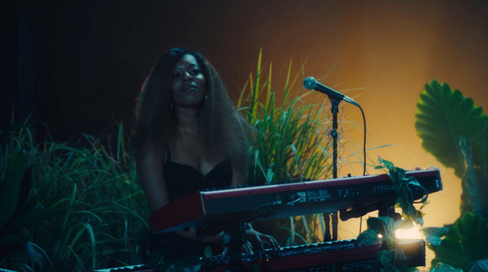 a woman standing in front of a keyboard in front of a microphone