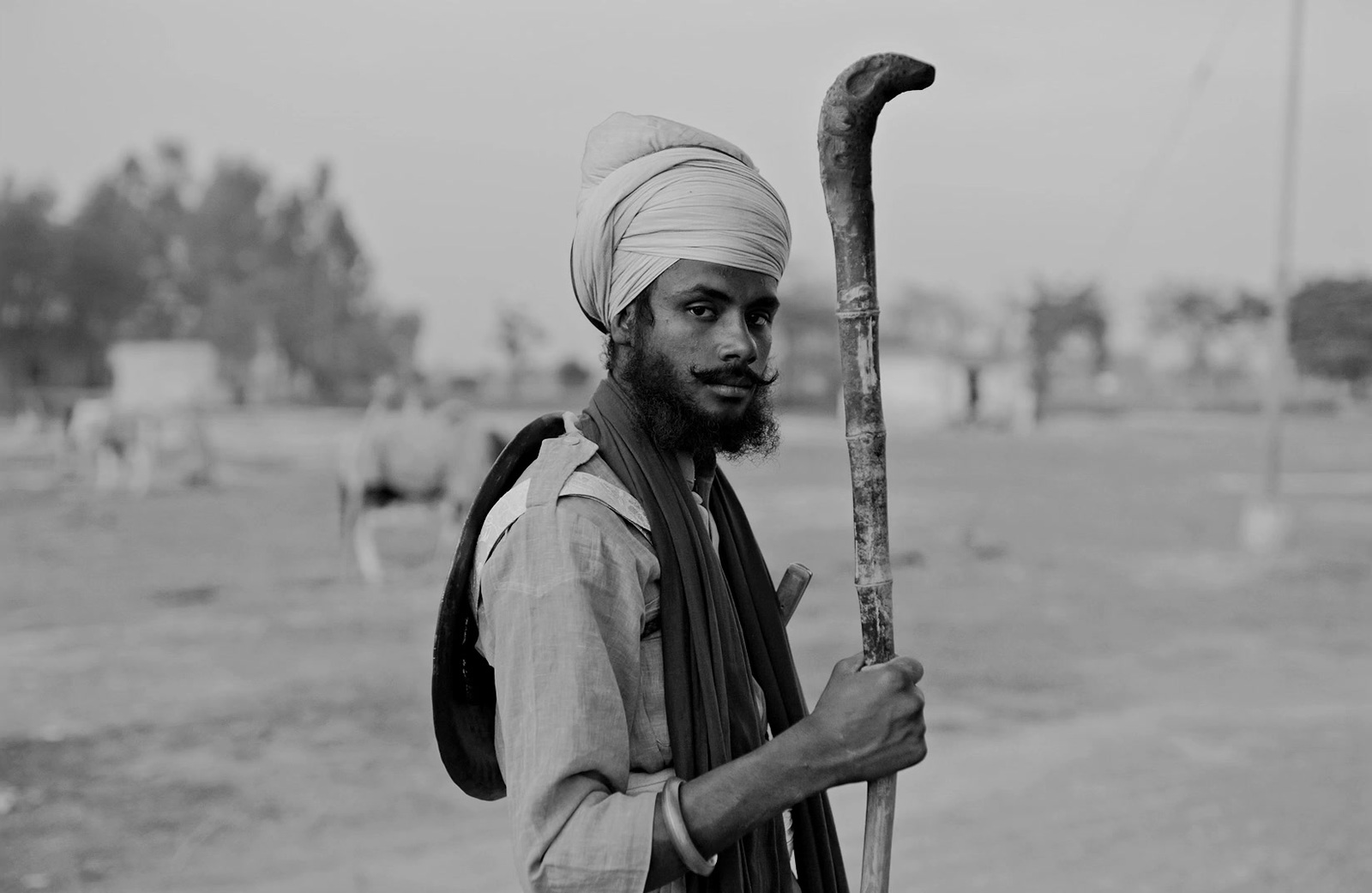 a man in a turban holding a stick