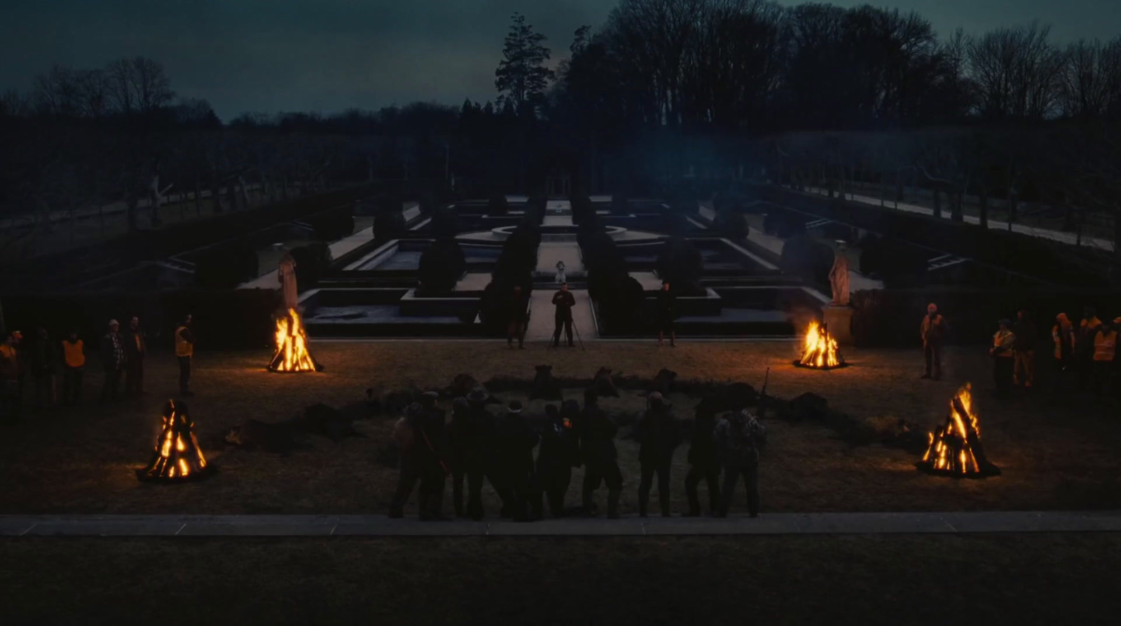 a group of people standing around a fire pit