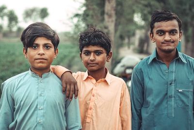 a group of three boys standing next to each other