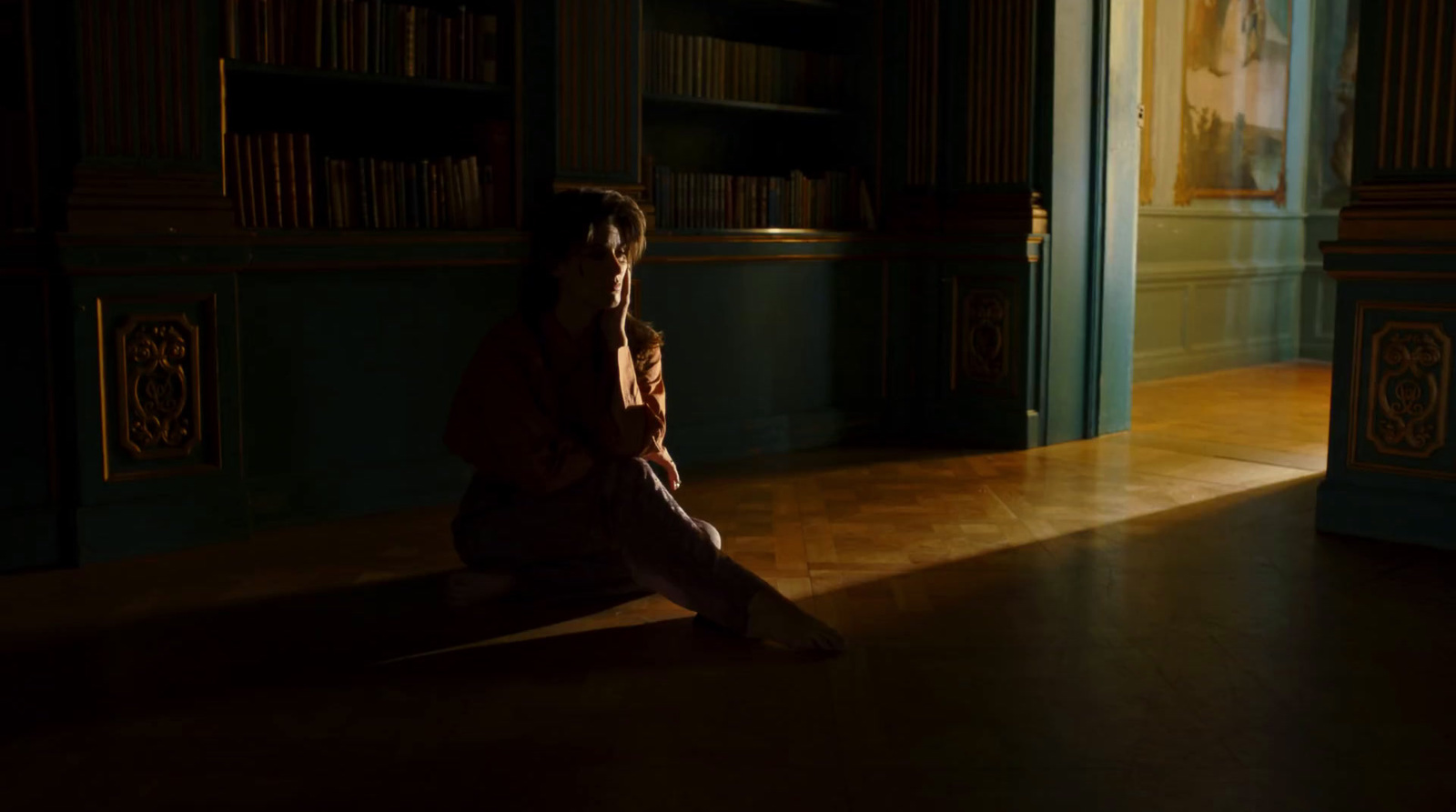 a woman sitting on the floor in a dark room