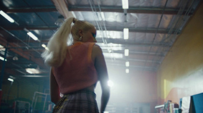 a woman with long blonde hair standing in a warehouse