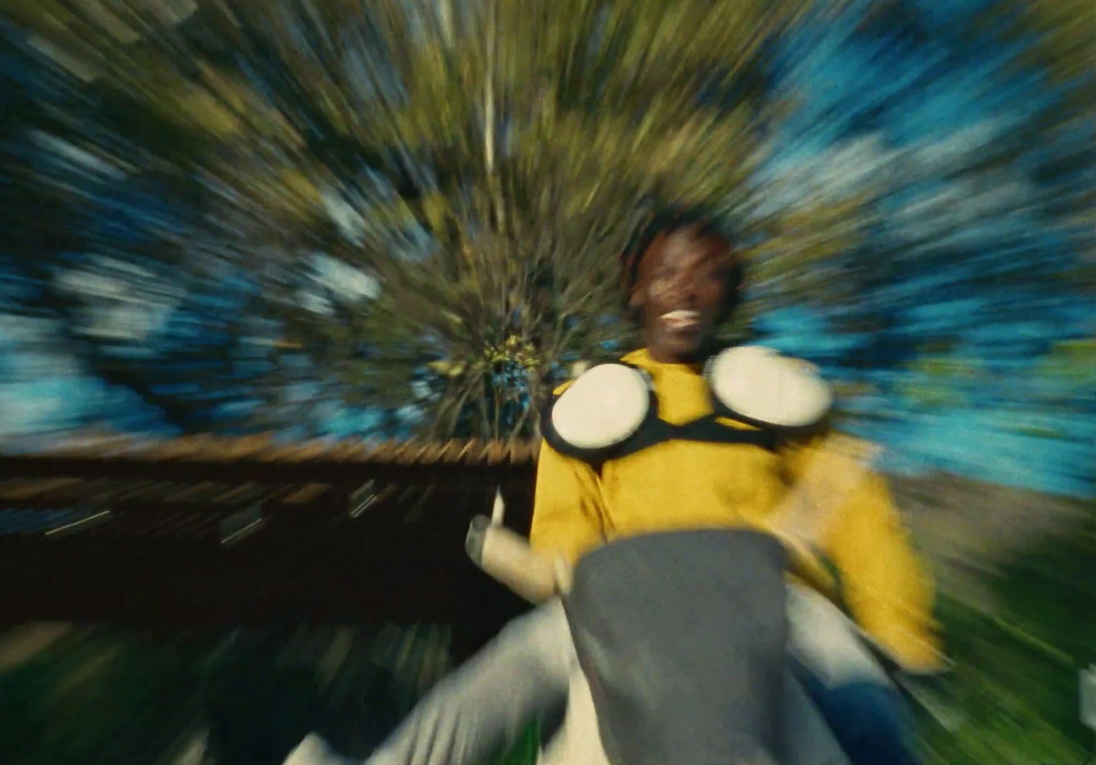 a man in a yellow shirt is riding a skateboard