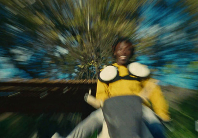 a man in a yellow shirt is riding a skateboard