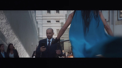 a man in a suit and tie walking down a street