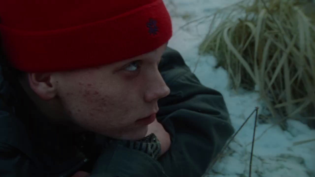 a man in a red hat is laying in the snow